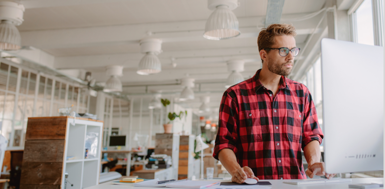 man standing at work desk